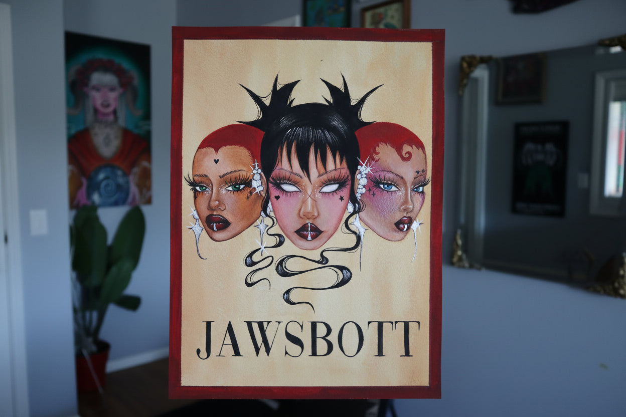 Card with 'Jawsbot' design held by a hand, with a blurred background of framed pictures.